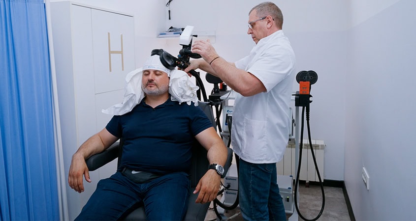 TMS Treatment with Doctor and Patient Doctor and patient during TMS treatment at MedTiM Clinic