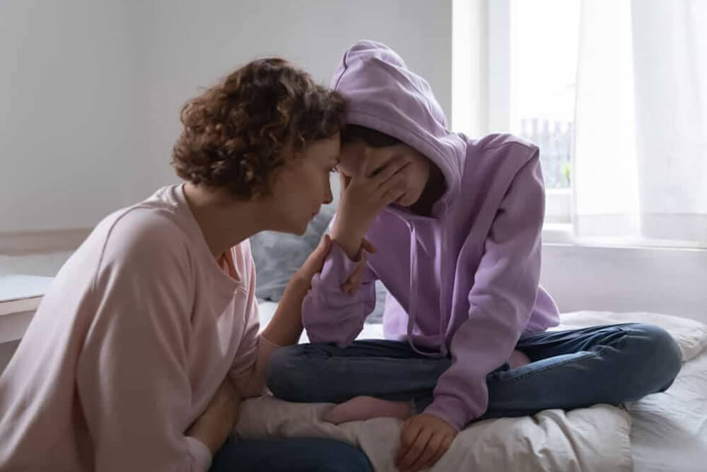 Codependent mother supporting addicted child during therapy